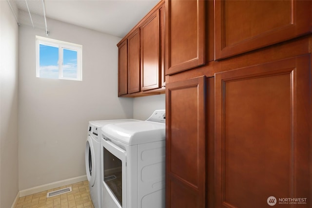 washroom featuring visible vents, washer and clothes dryer, cabinet space, and baseboards