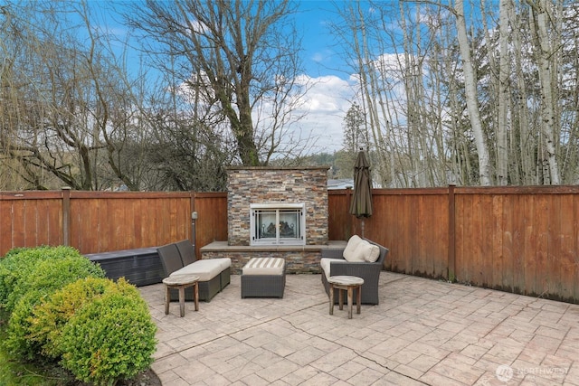 view of patio featuring an outdoor living space with a fireplace and a fenced backyard