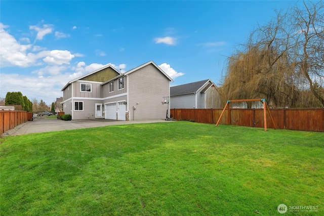 back of house with a garage, board and batten siding, a lawn, and a playground