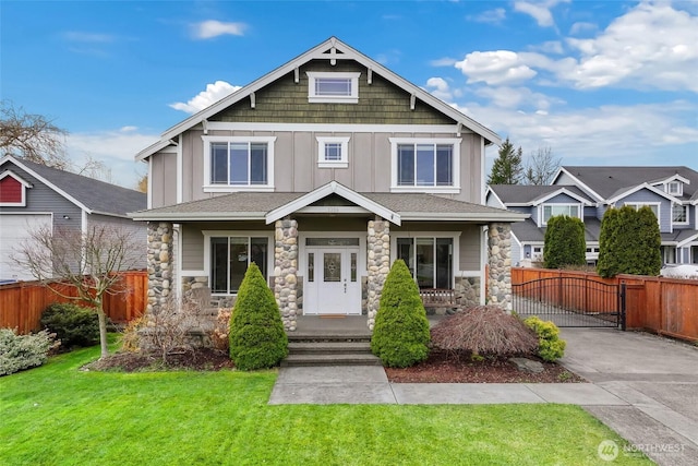 craftsman house featuring a gate, fence, a front lawn, and board and batten siding