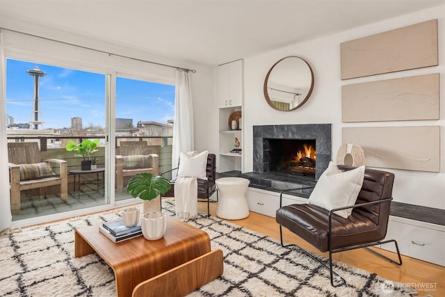 living area with light wood finished floors and a tiled fireplace