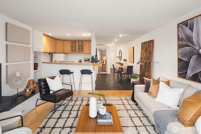 living area featuring light wood-type flooring and recessed lighting