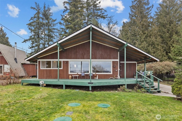 view of front of home featuring a deck, fence, and a front lawn