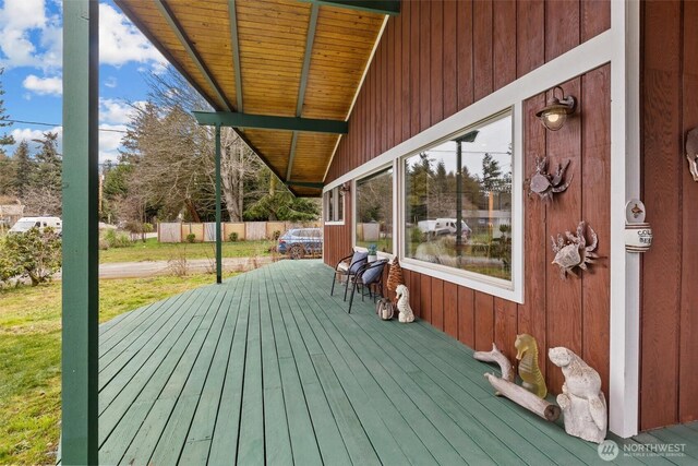 wooden deck with a yard and fence