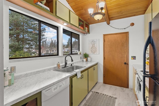 kitchen featuring white appliances, light countertops, a sink, and decorative light fixtures