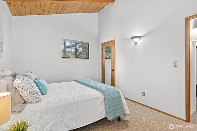 carpeted bedroom with wooden ceiling, vaulted ceiling, and baseboards