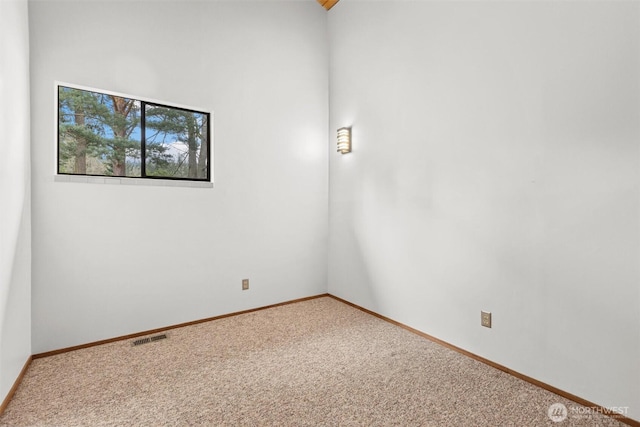 carpeted spare room with baseboards and visible vents