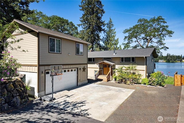 view of front of property featuring an attached garage, concrete driveway, board and batten siding, and a water view