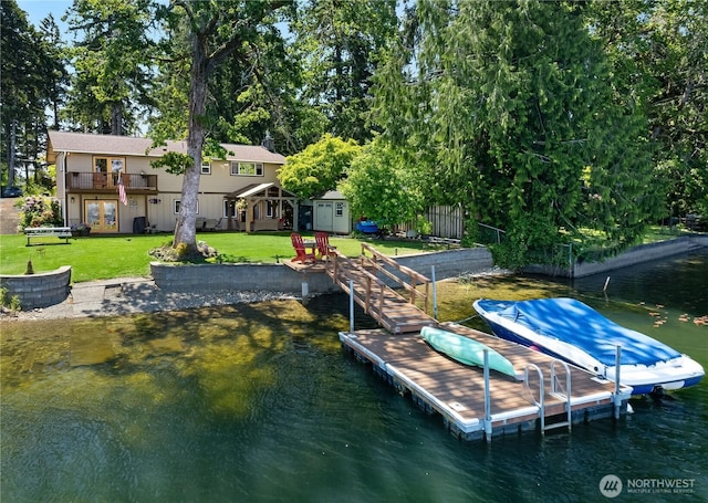 view of dock with a water view and a lawn