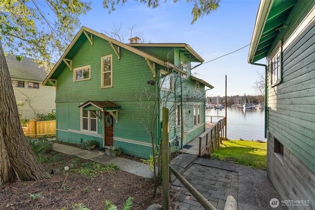 exterior space featuring a water view and fence