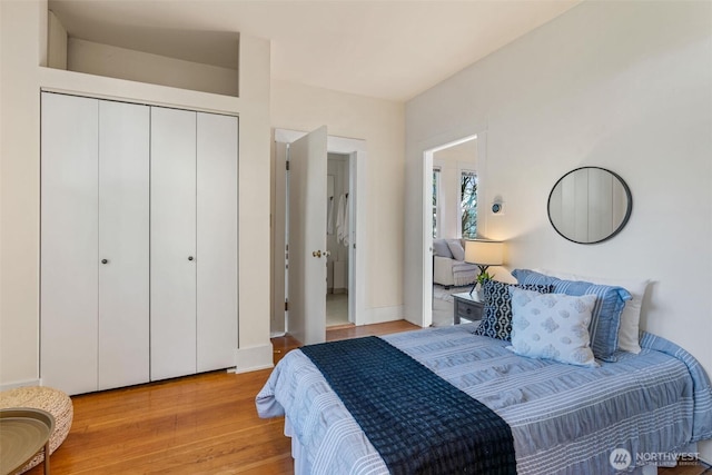 bedroom featuring a closet, baseboards, and light wood finished floors