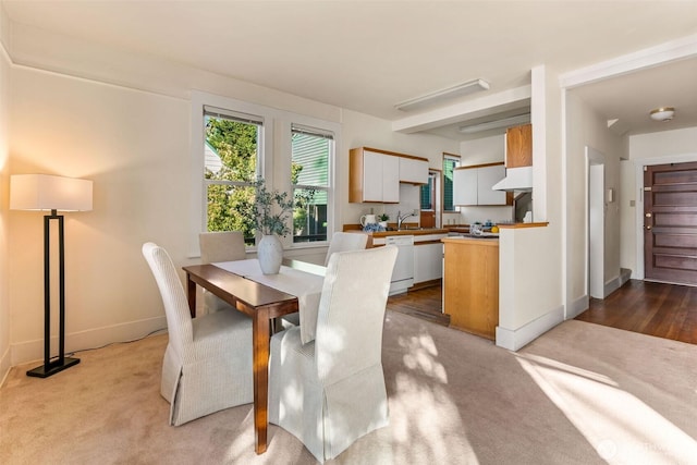 carpeted dining area with baseboards