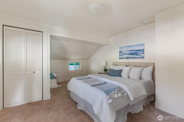 carpeted bedroom with attic access, a closet, and vaulted ceiling