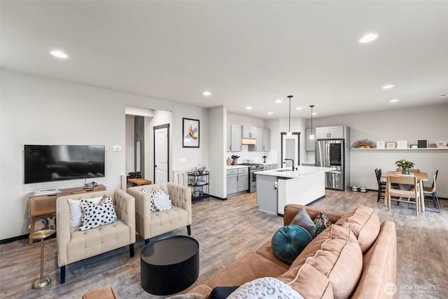 living room with baseboards, light wood-style flooring, and recessed lighting