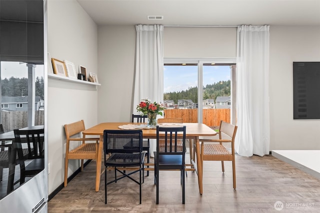 dining room featuring wood finished floors, visible vents, and baseboards