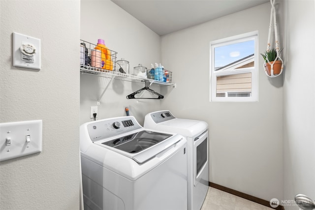 laundry area featuring laundry area, washing machine and dryer, and baseboards