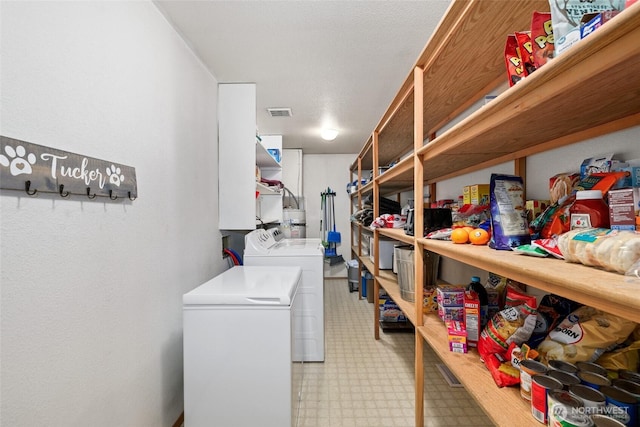 laundry area featuring visible vents, light floors, and washing machine and clothes dryer