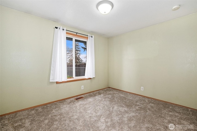 carpeted spare room featuring visible vents and baseboards