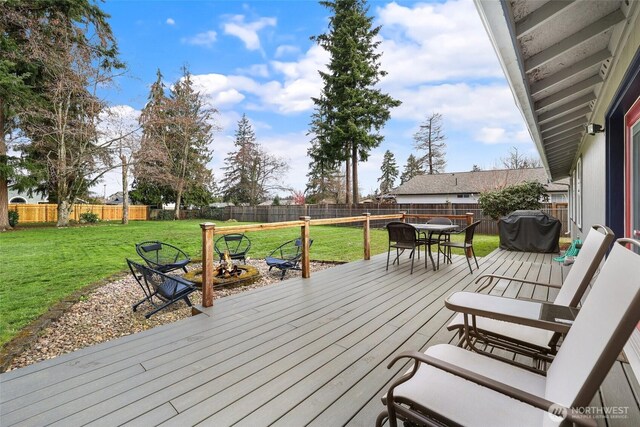 wooden terrace featuring a yard, outdoor dining area, area for grilling, and a fenced backyard