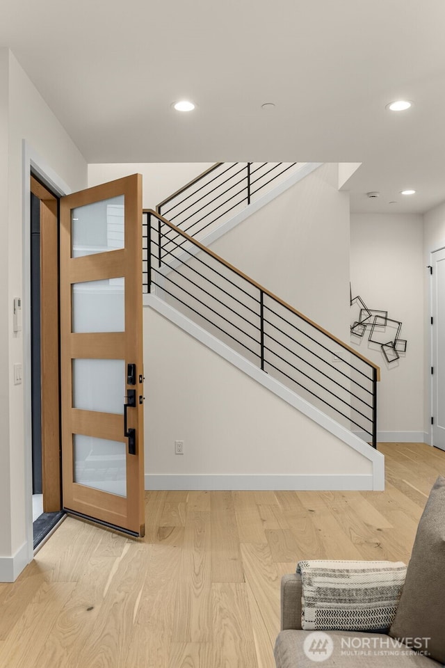 stairway with recessed lighting, baseboards, and wood finished floors