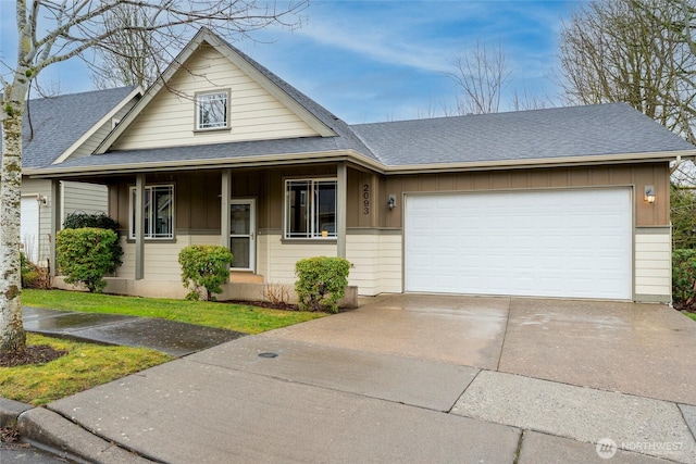 view of front facade featuring a garage, driveway, board and batten siding, and roof with shingles