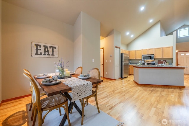 dining area with light wood-type flooring, baseboards, high vaulted ceiling, and recessed lighting