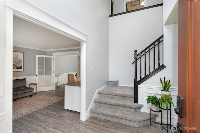 stairway featuring french doors, crown molding, baseboards, and wood finished floors