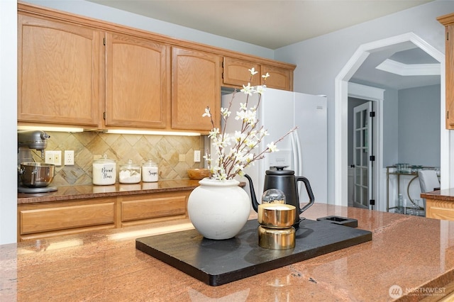 kitchen with granite finish floor, tasteful backsplash, stone countertops, and freestanding refrigerator