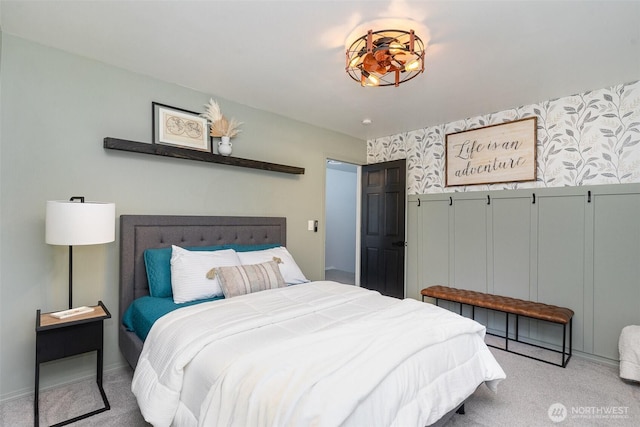 carpeted bedroom with a decorative wall