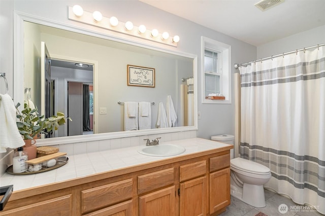 full bath with toilet, vanity, visible vents, and tile patterned floors