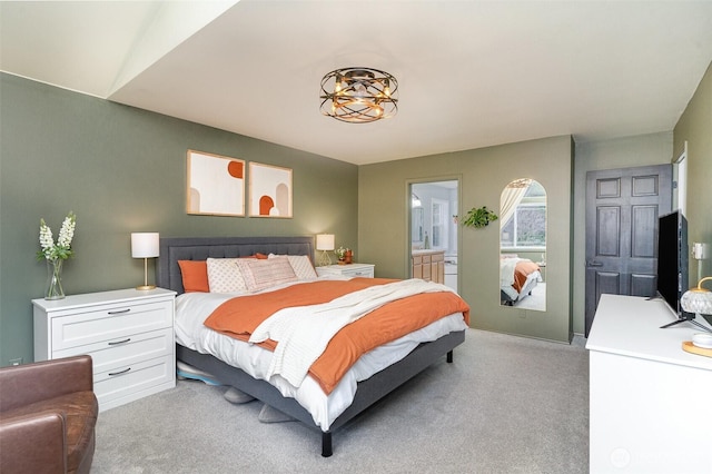 bedroom featuring light carpet and connected bathroom