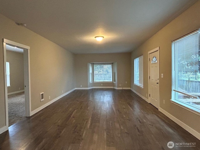 entryway with dark wood-style floors, visible vents, and baseboards