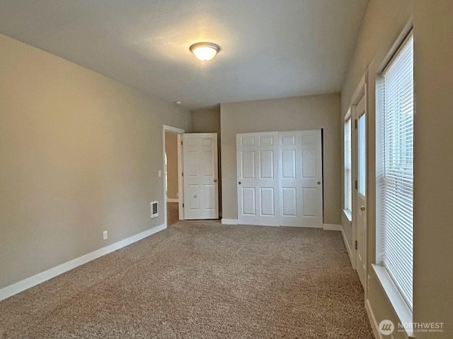 unfurnished bedroom featuring carpet, visible vents, and baseboards