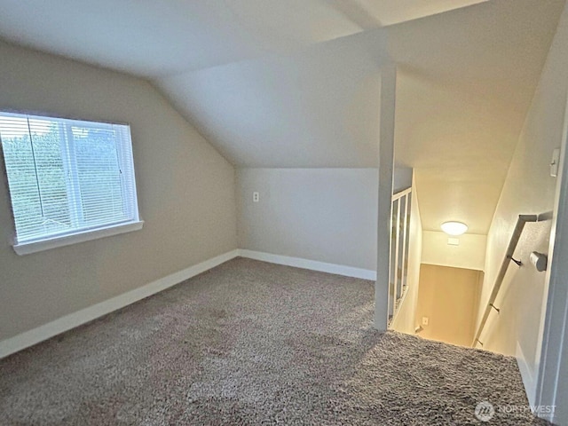 additional living space featuring vaulted ceiling, carpet floors, and baseboards