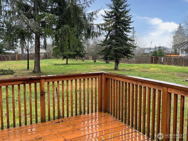 wooden deck featuring a fenced backyard and a yard