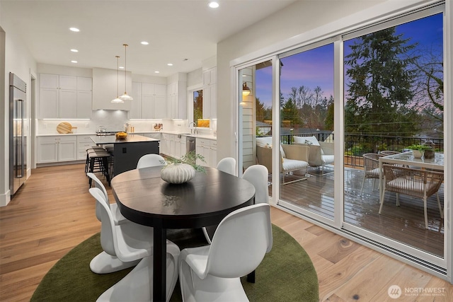 dining room with light wood finished floors and recessed lighting