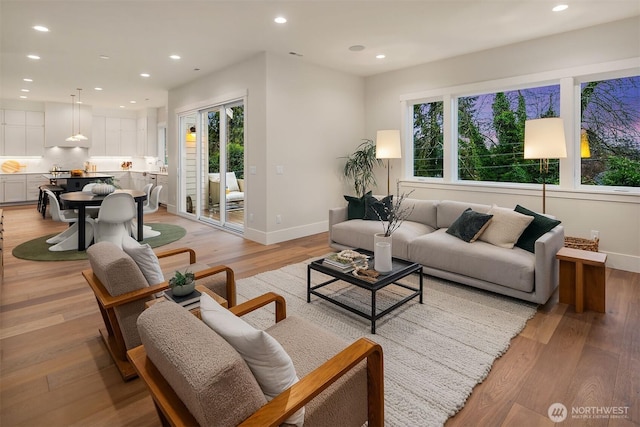 living room with light wood-style flooring, a wealth of natural light, and recessed lighting