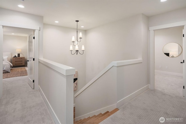 corridor featuring recessed lighting, baseboards, light colored carpet, and an upstairs landing