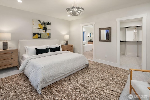 bedroom with a walk in closet, recessed lighting, a closet, light colored carpet, and baseboards