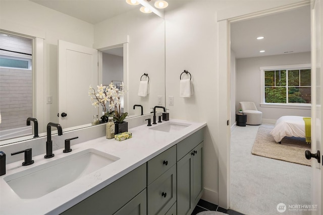 ensuite bathroom with ensuite bathroom, double vanity, a sink, and recessed lighting