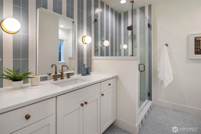 bathroom featuring tile patterned flooring, a shower stall, vanity, and baseboards