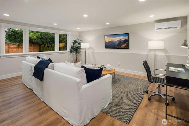 living room with baseboards, a wall mounted AC, wood finished floors, and recessed lighting