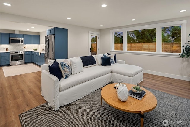 living room featuring recessed lighting, light wood-style flooring, and baseboards