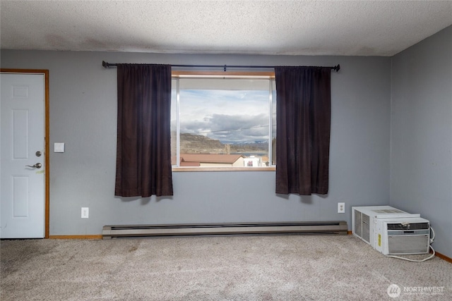 unfurnished room featuring a wall mounted air conditioner, baseboard heating, a textured ceiling, and light colored carpet