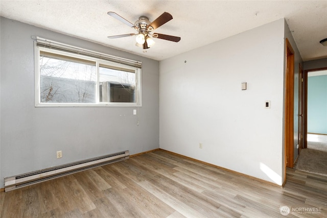 spare room featuring a textured ceiling, a ceiling fan, baseboards, baseboard heating, and light wood finished floors