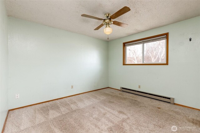 empty room featuring a baseboard heating unit, a ceiling fan, light carpet, a textured ceiling, and baseboards