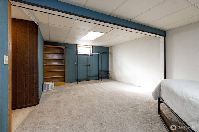 unfurnished bedroom with a drop ceiling and light colored carpet