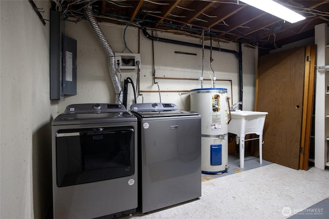 laundry room featuring laundry area, washing machine and clothes dryer, strapped water heater, and electric panel