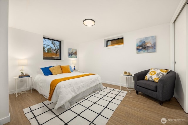 bedroom featuring a closet, wood finished floors, and baseboards