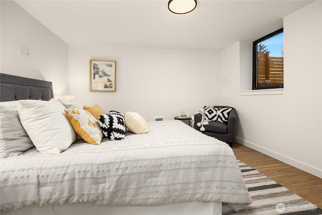 bedroom featuring visible vents, baseboards, and wood finished floors